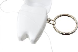 Praktická klíčenka s přívěškem zubu s dentální nití